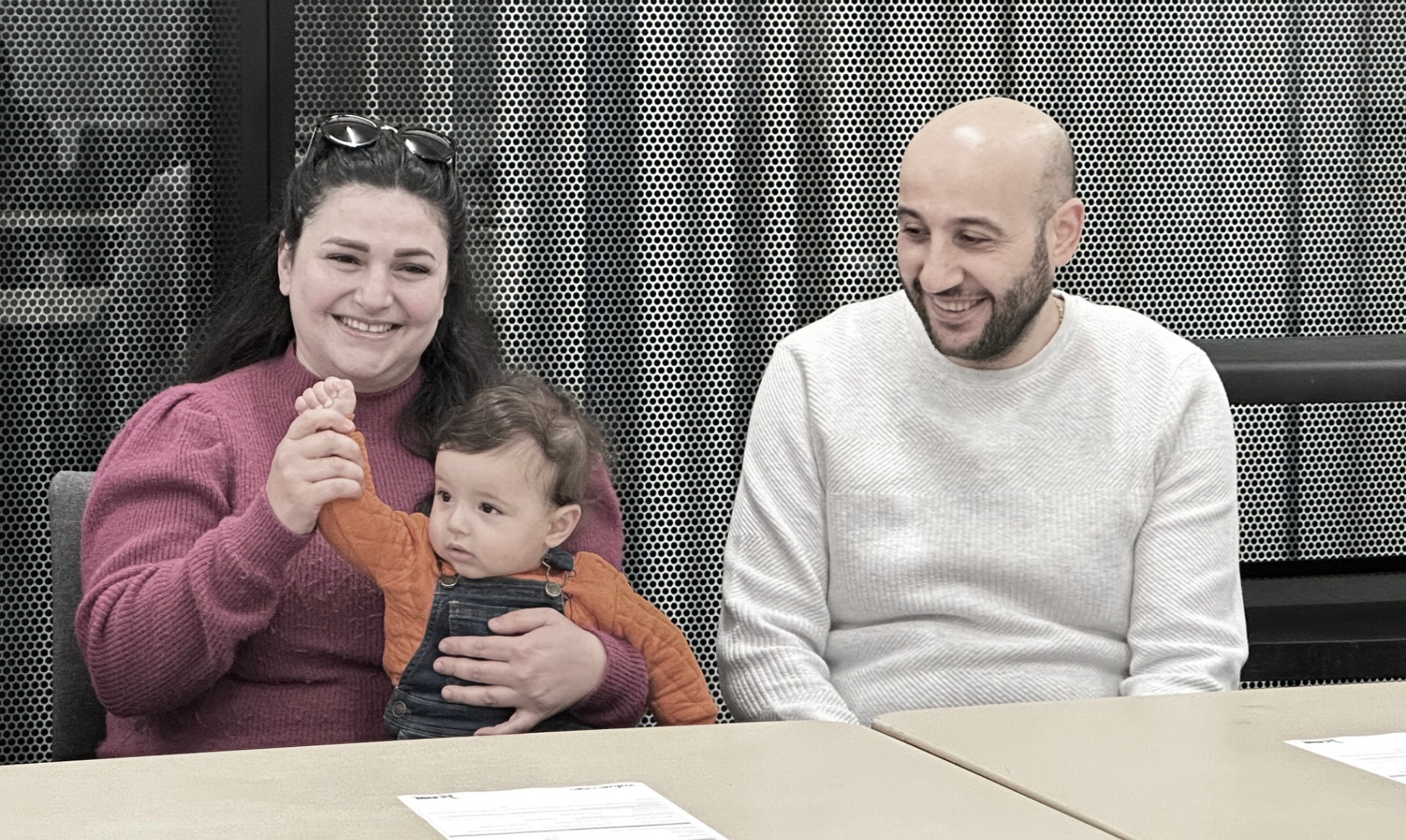 A family smiling together during a community business session.